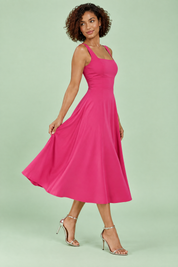 Robe midi rose vif à fines bretelles et jupe évasée | Vue de dos | Lounelle Paris