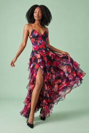 Robe longue noire asymétrique à manches cape et imprimé lys | Vue en mouvement | Lounelle Paris